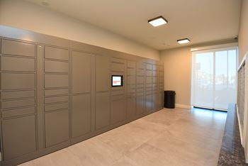 A room with a wall of lockers and a monitor on the wall